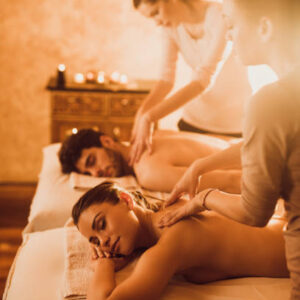 Young couple having a relaxing back massage at beauty spa.