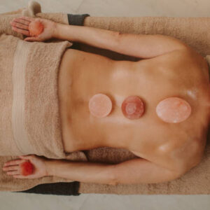 Mature woman enjoy Back massage with Himalayan salt stones in beauty salon