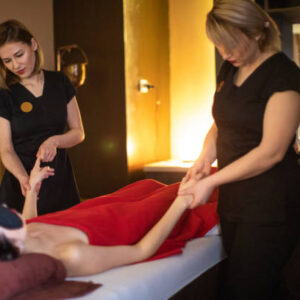 Two massage therapist giving relax massage to woman at massaging room at the spa