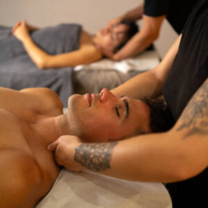 Man next to his couple enjoying a massage in a luxury spa