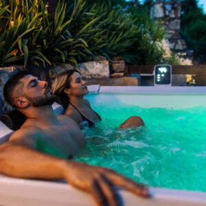 A mid adult couple, laying in jakuzzi, listening to music and relaxing. It's a night time and it's peaceful.