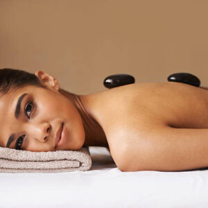 A young ethnic woman receiving a hot stone treatment at a spa
