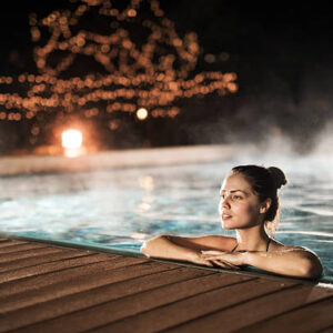 Woman spending a winter night in a heated swimming pool.