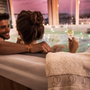 Close up of a white towel on a hot tub with young couple in it.