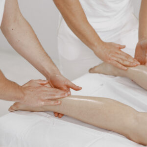 The massage with four hands. Concept of healthcare and female beauty. Two masseuses make a double  massage of a girl. Woman in a spa salon.