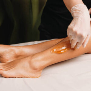 Close up photo of a sugaring procedure done at the salon during a leg skin protection session